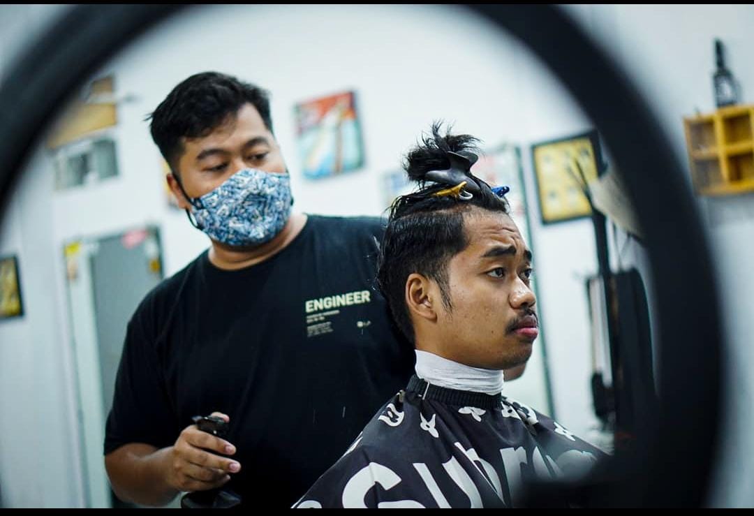 Aprizal tengah menunjukkan kelihaianya mencukur rambut pelanggan. (Muhamad Faisal/Pasundan Ekspres)