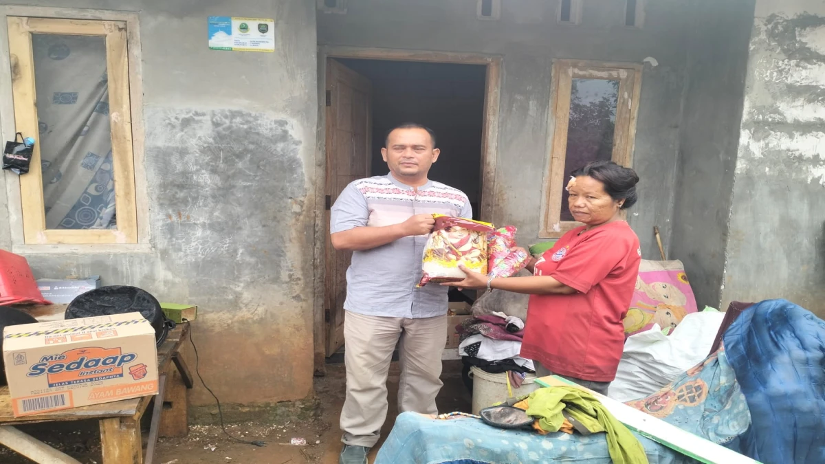 Kepala SDN Gunung Sembung, Gingin Ginanjar Taufiq ketika memberi bantuan kepada orang tua korban, pada Jum'at (7/1).