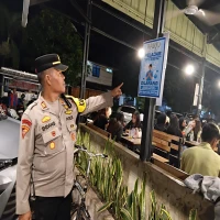 Kapolsek Subang AKP Endang Suganda menunjukkan papan informasi mengenai jam malam bagi pelajar.