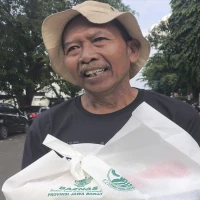 Wajah penuh kebahagiaan terpancar dari sosok Danto, seorang pedagang nanas asal Subang, usai menerima dana kompensasi sebesar Rp5 juta.